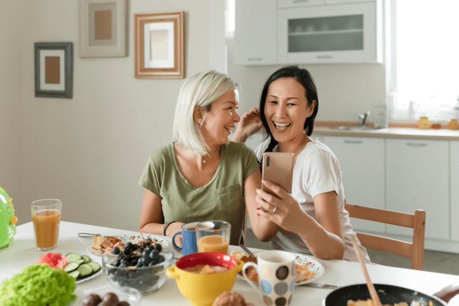 A couple sitting down enjoying breakfast in the kitchen of their home.