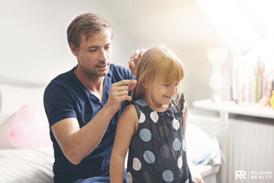 Dad playing with his daughter hair while she is laughing