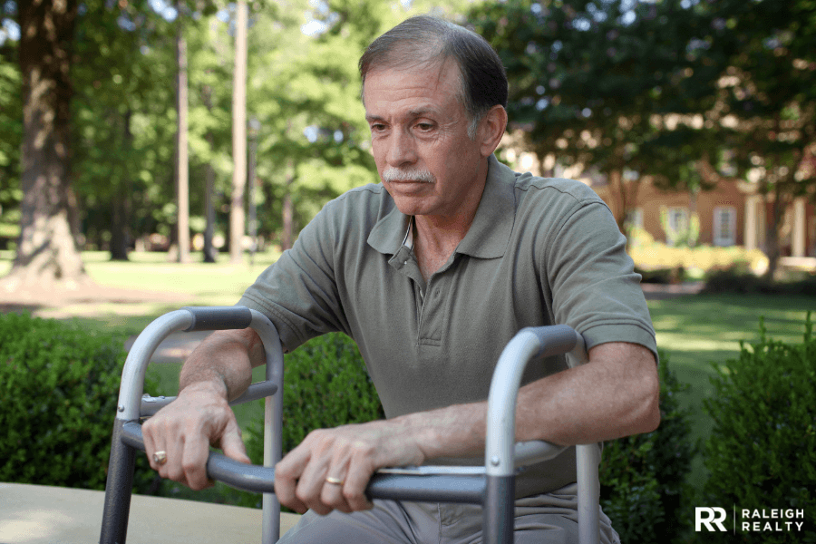 Disabled gentleman with walker sitting on a park bench