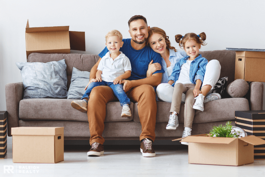 A family sitting on a couch after relocating and making a move to a new area