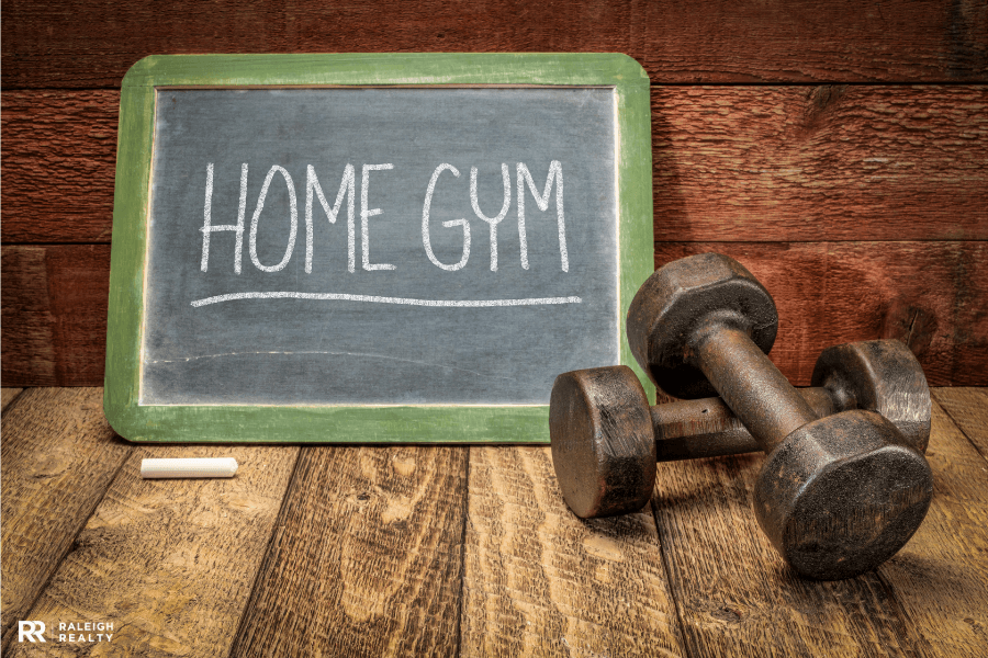 Weights with a sign in the background that says home gym