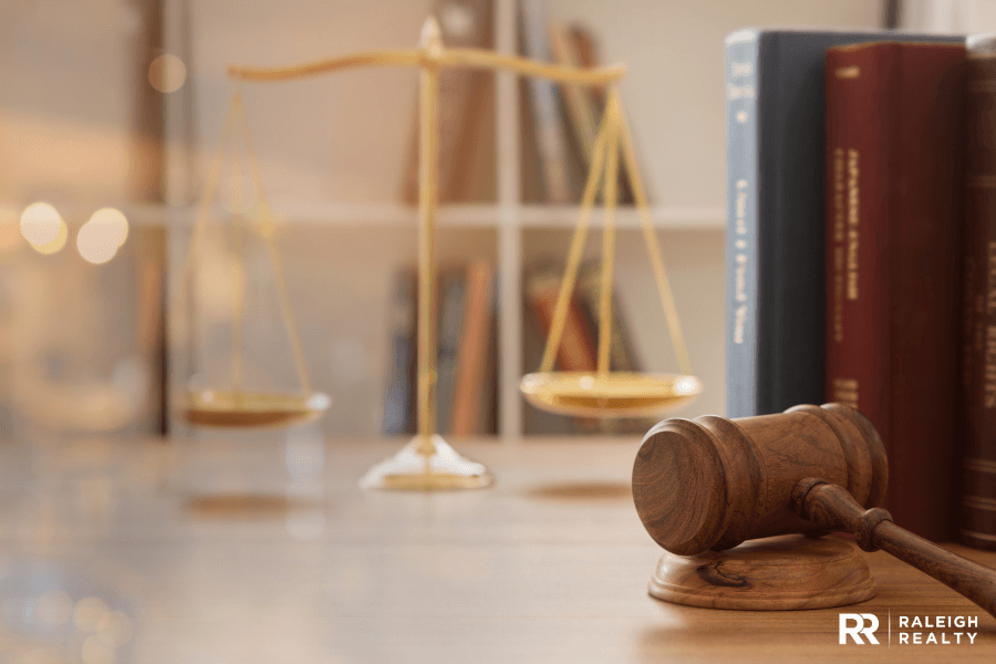 A close up of a judge's office with a gavel on the desk and legal books in the background