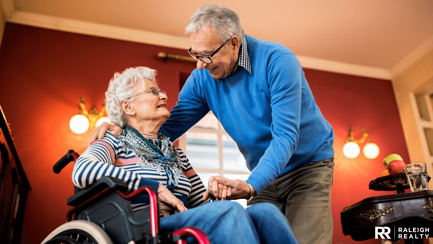 An elderly man caring for his his elderly wife who is in a wheelchair