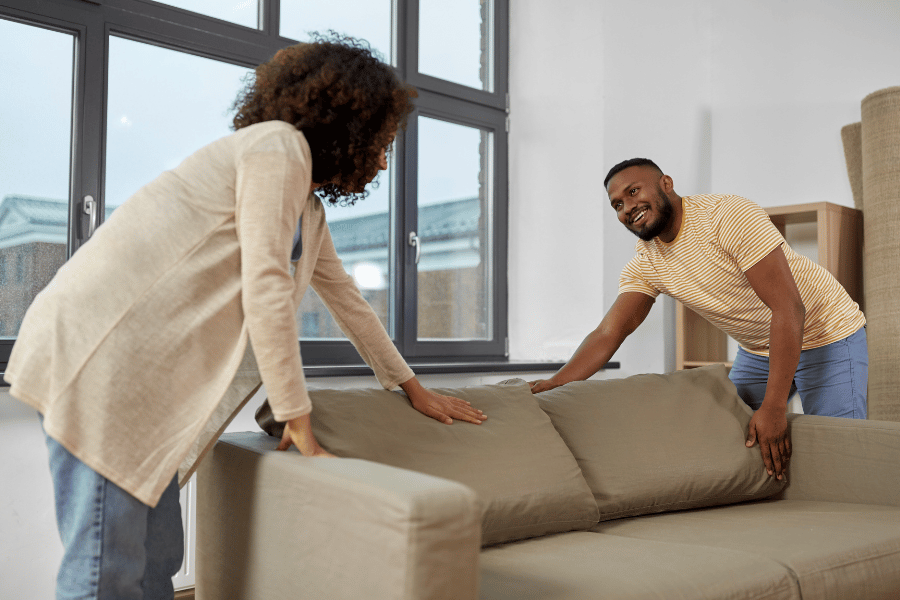 couple moving living room couch into new home when they moved states