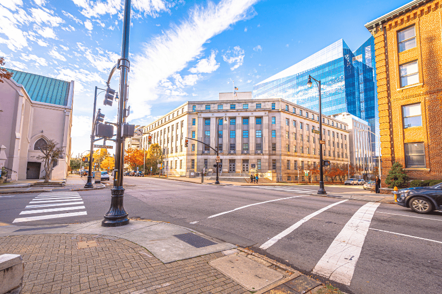 corner of a Raleigh city street with cars driving and city buildings