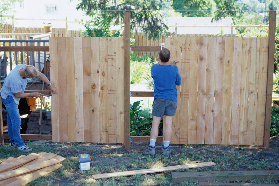 A couple building their own fence in their yard