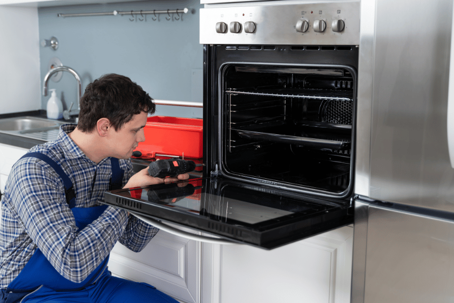 Professional unscrewing and opening the oven door