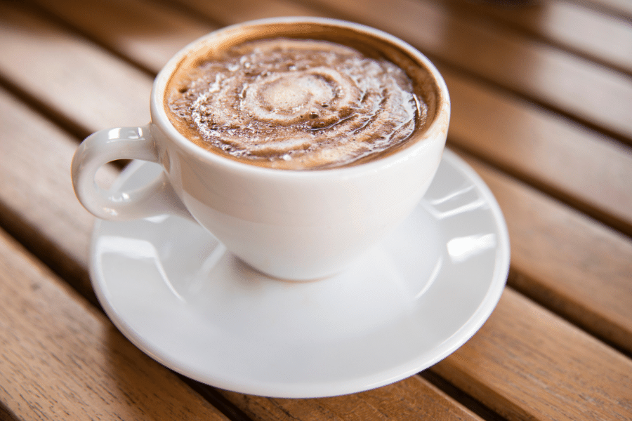 white cup of mocha coffee on a wood background