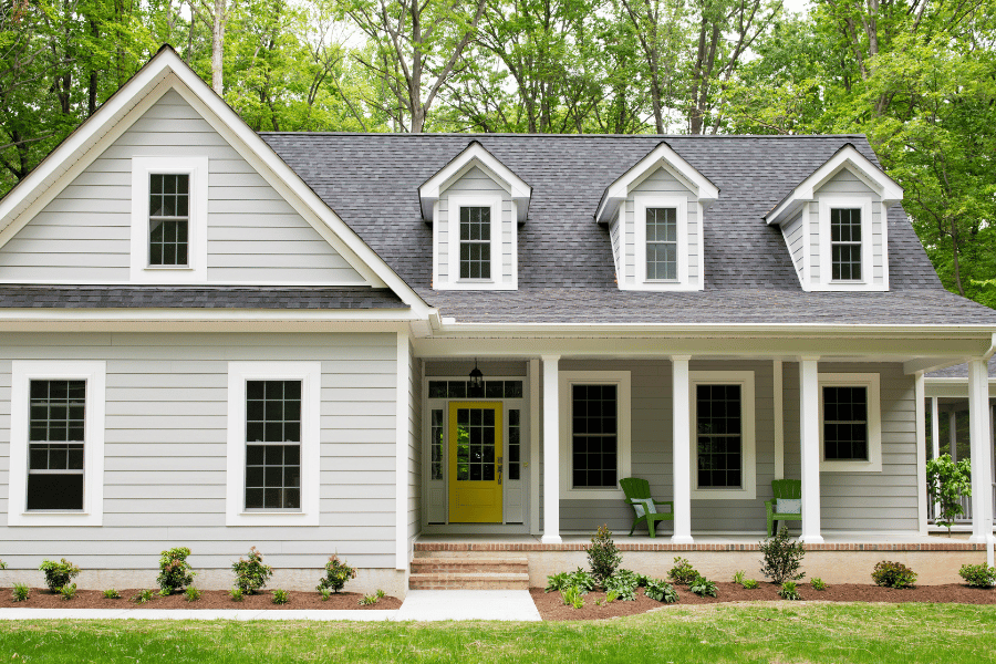 beautiful suburban single-family home with a yellow door and front porch