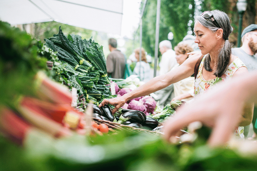 People shopping for fresh produce and goods at local farmers market