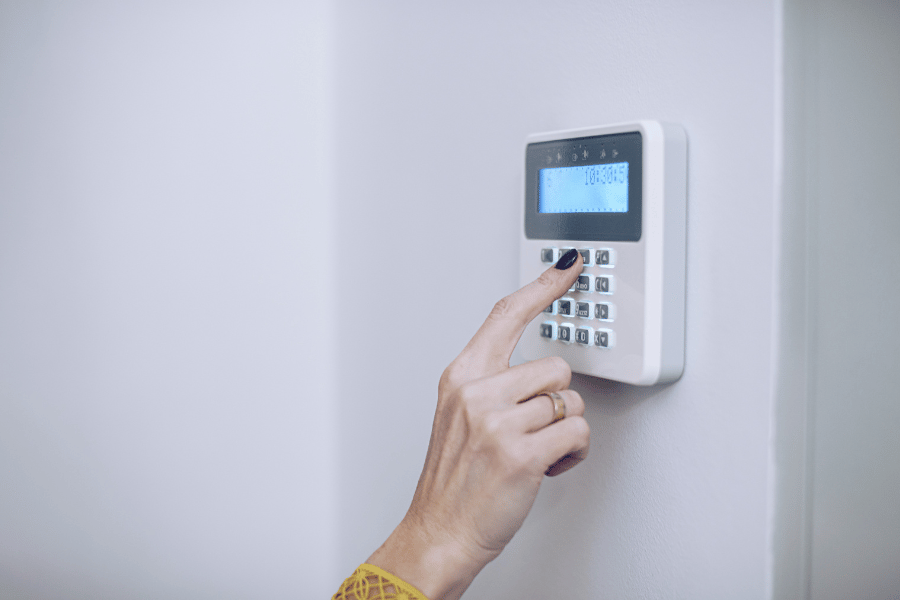 homeowner setting up their alarm system at home to stay safe