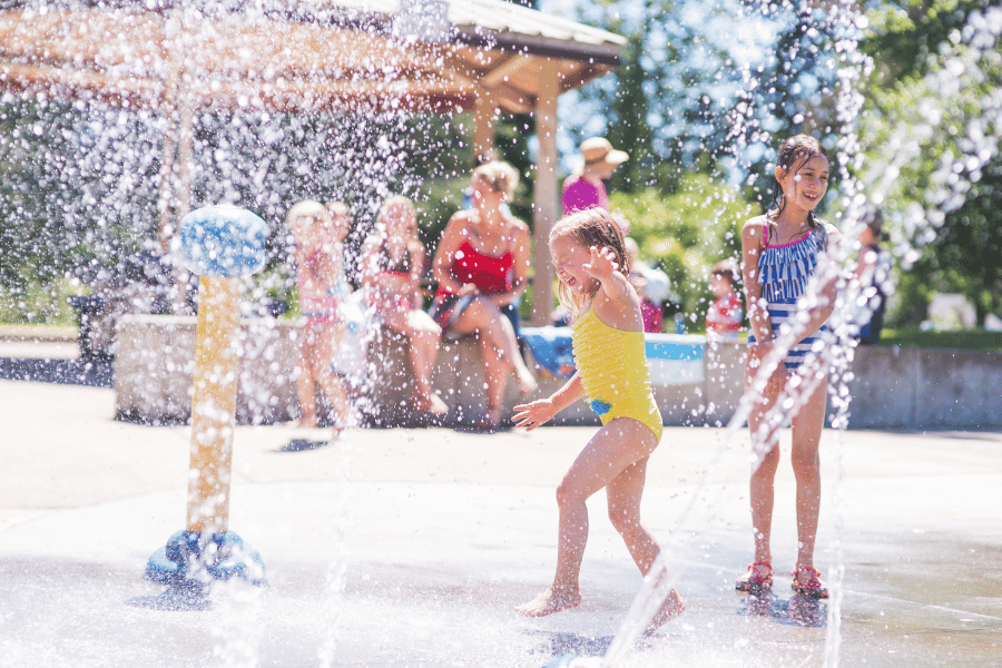 Kids playing in a splash pad on a hot day 