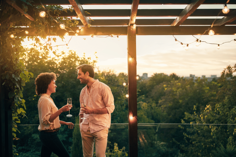 couple on a summer date on a rooftop bar overlooking the city with lush greenery