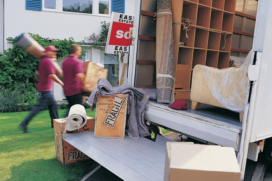 professional movers loading up truck with moving boxes and furniture