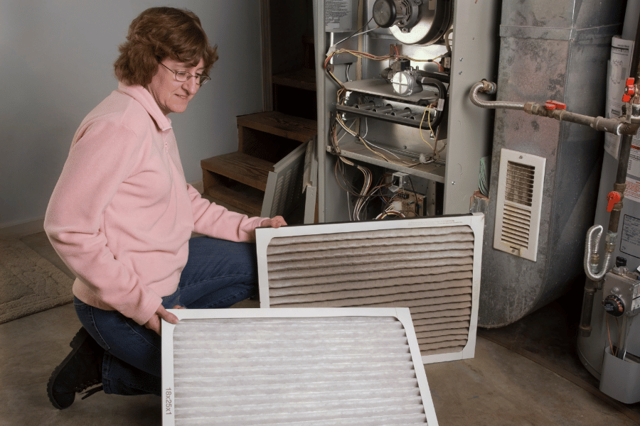 Woman changing her own air filter in garage