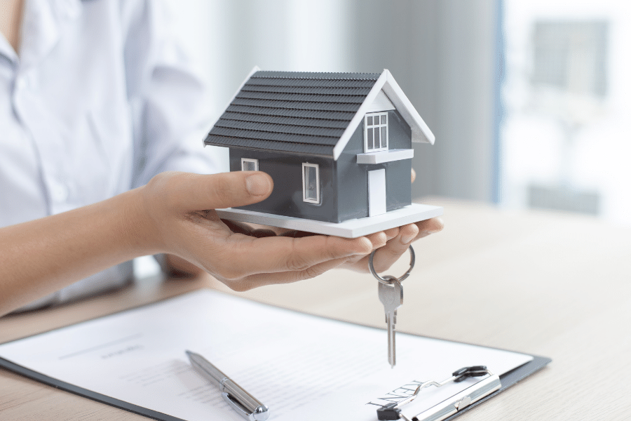 Person holding keys and a house