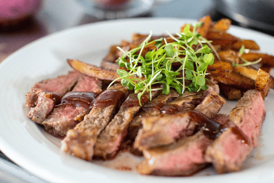 steak in a white bowl at a restaurant 