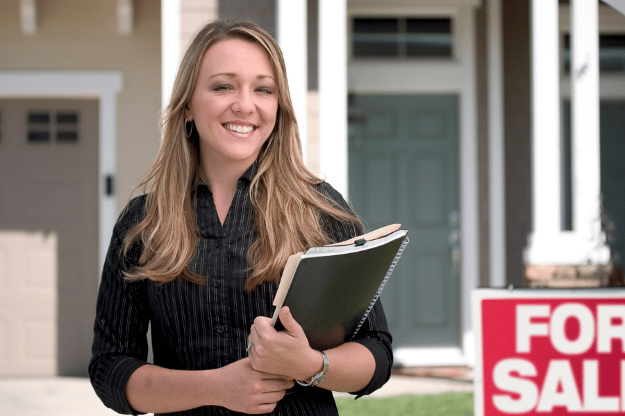 hardworking realtor standing outside of a home for sale and hosting an open house