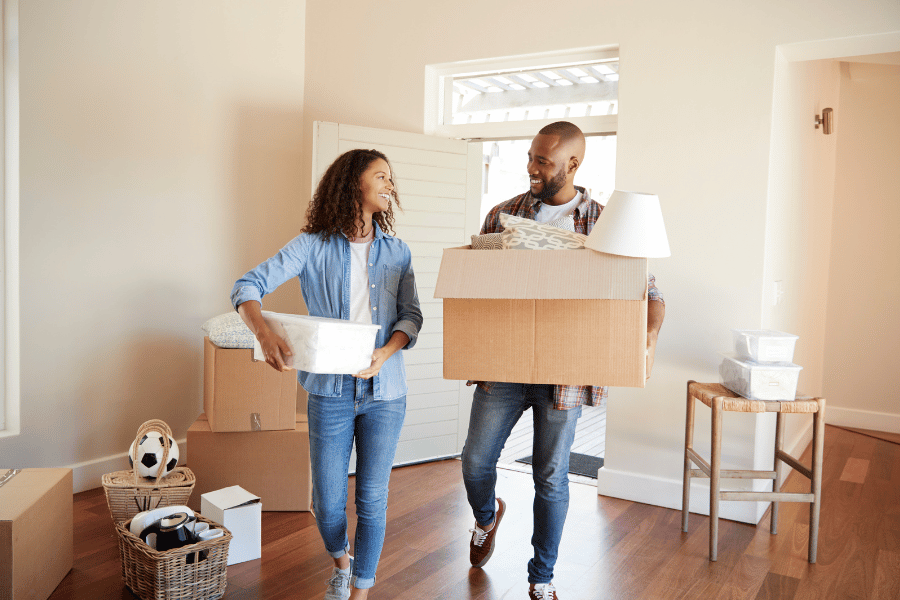 young couple packing for a move and carrying boxes 