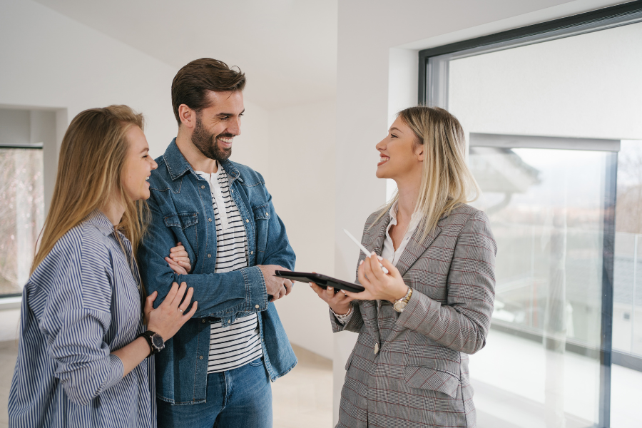 Couple working with and talking to a real estate agent when looking for a new home