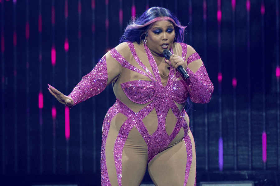 Lizzo performing on stage in pink outfit