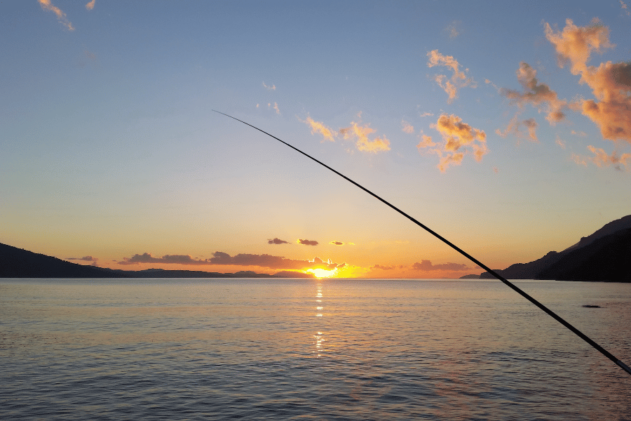 fishing during beautiful sunset with a fishing pole 