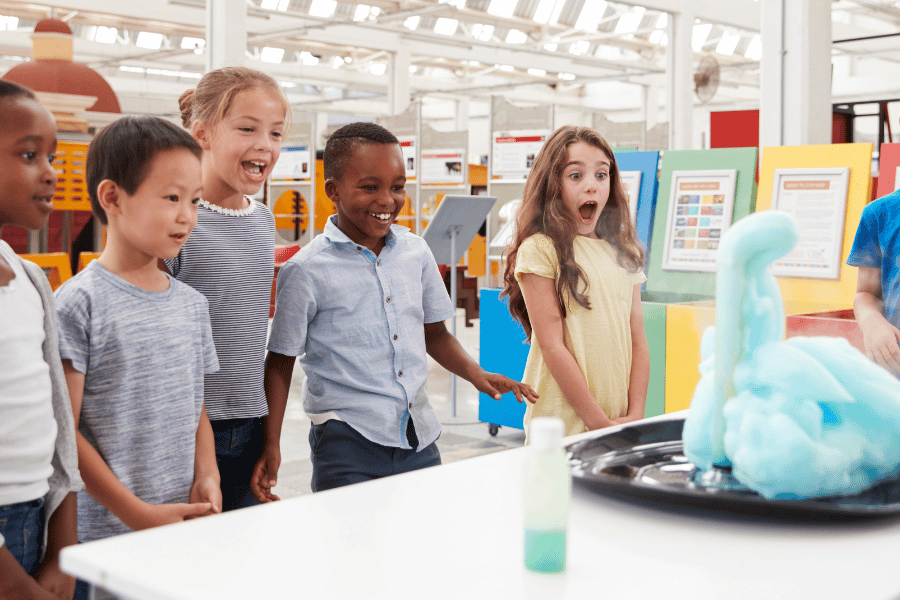 kids at a kids museum looking at a science experiement 