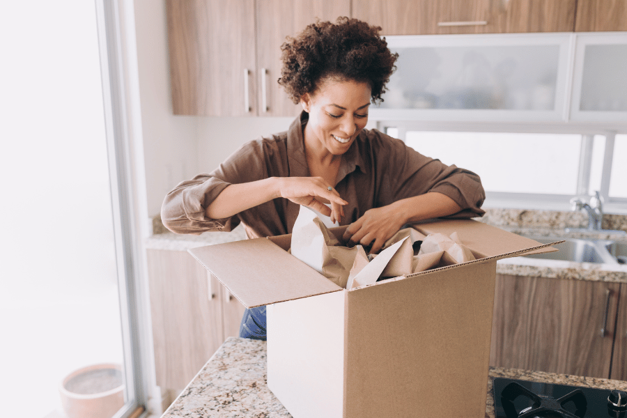 Woman packing kitchen and fragile items in box 