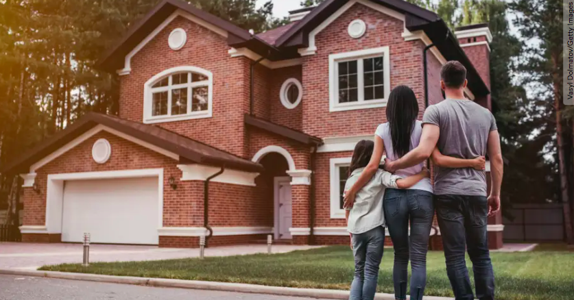 Family standing in front of new home 