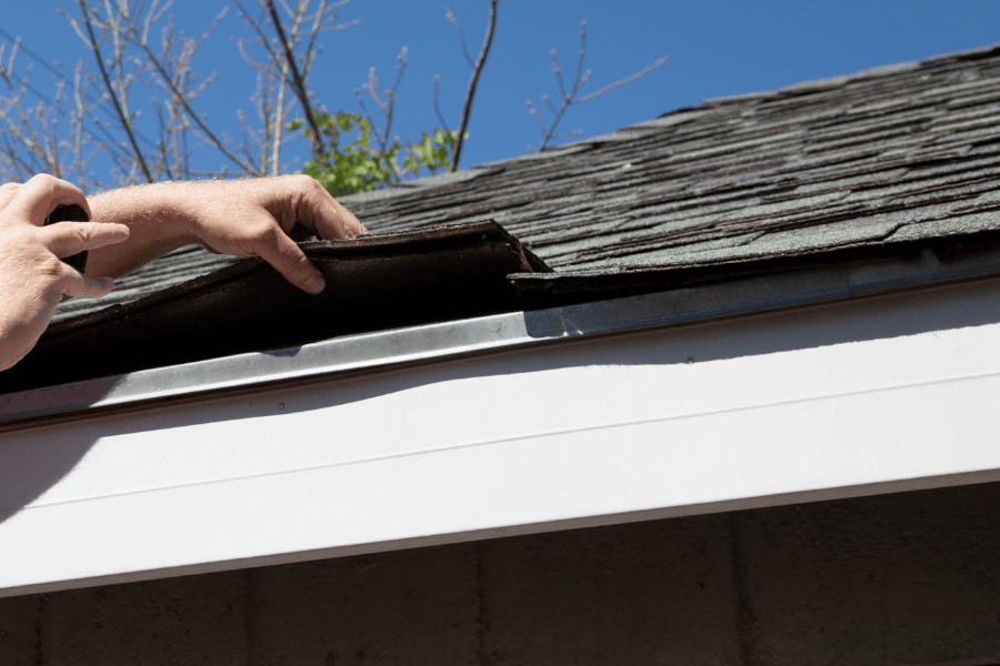 Inspecting the roof for any broken shingles to repair