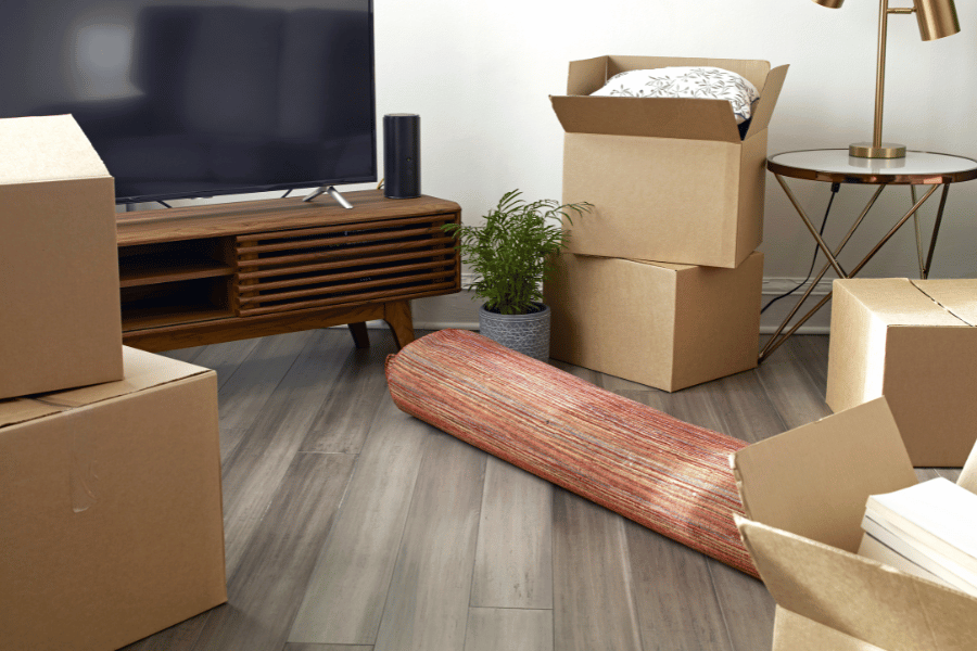 Living room items packed away in boxes and rug rolled up during move
