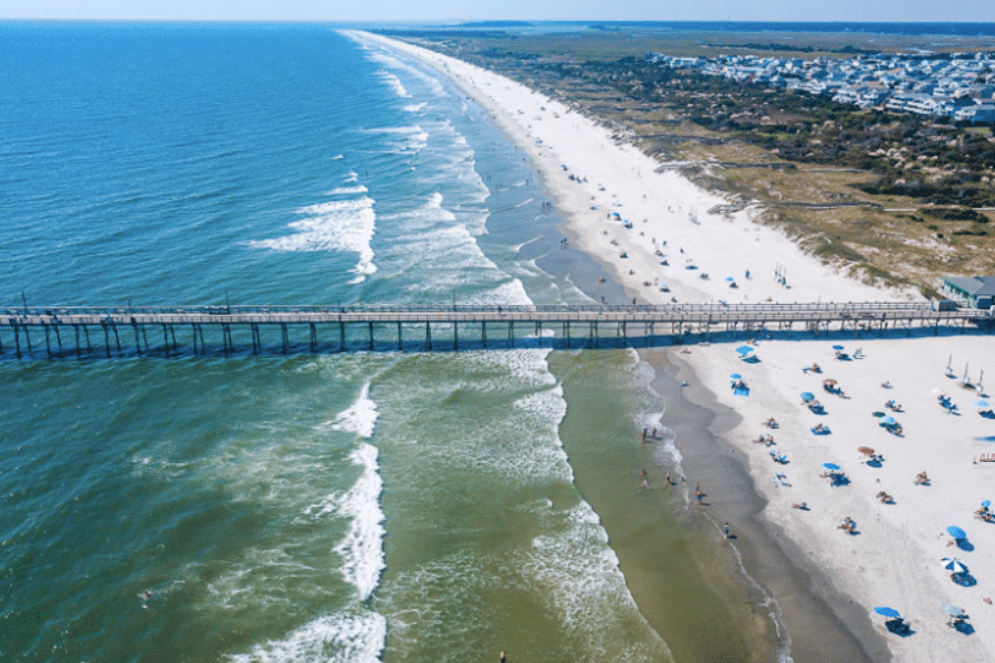 North Carolina beach with pier and beachgoers on a sunny day