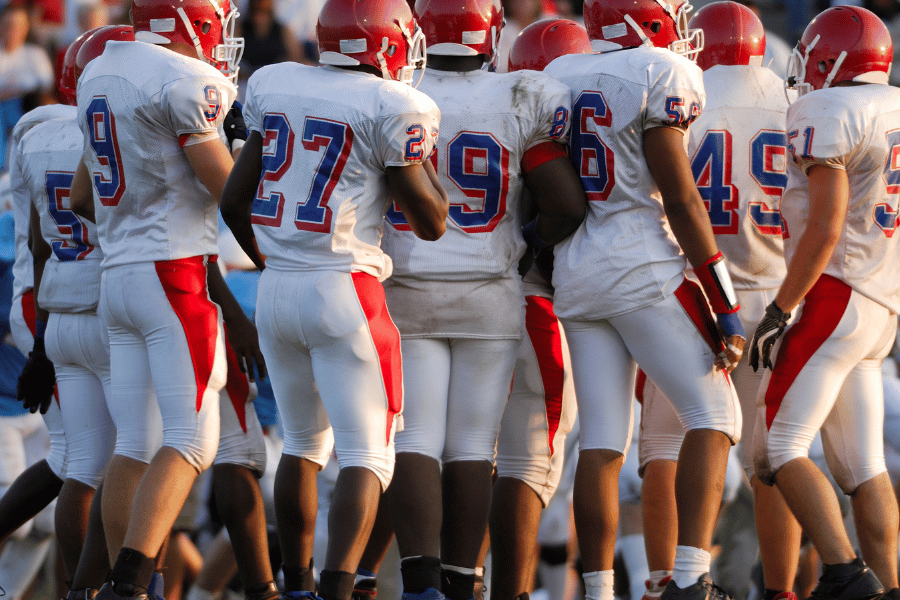 high school football players wearing orange helmets