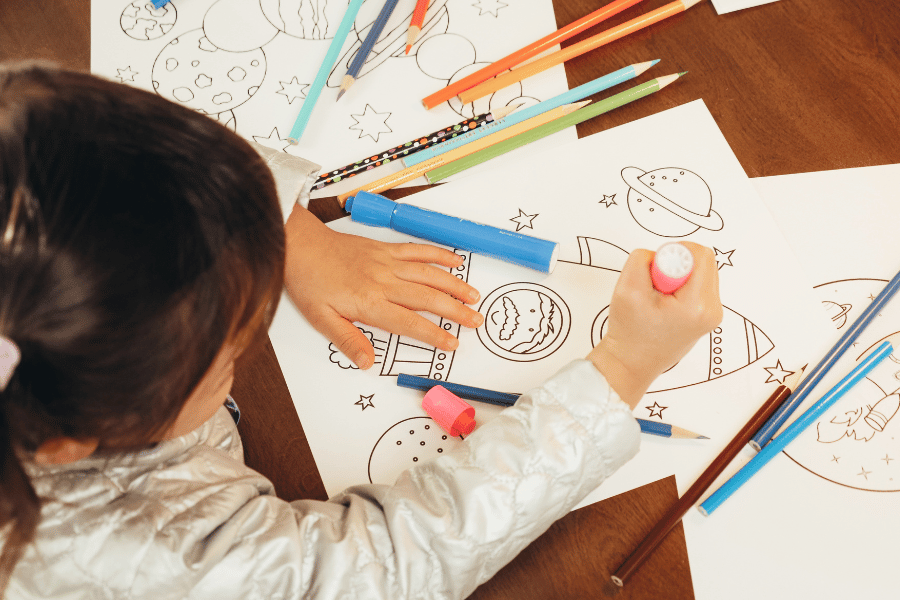 child coloring with markers and pencils at daycare 