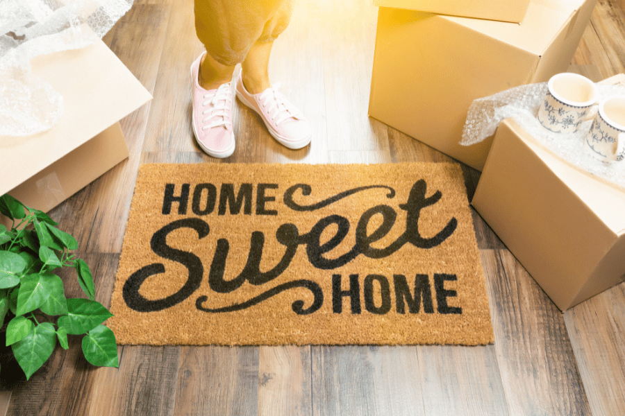 home sweet home welcome mat with moving boxes
