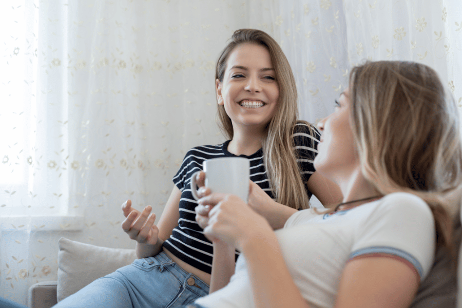 roommates hanging out and talking on the couch 