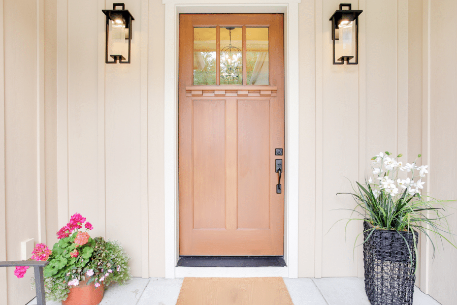 Front door with flowers and two lights 
