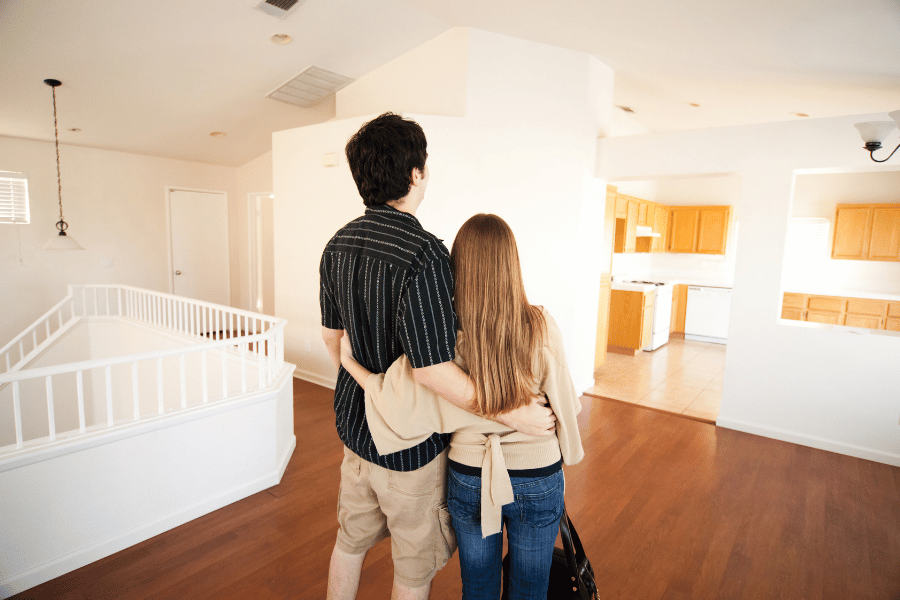 young couple walking through home that they might buy