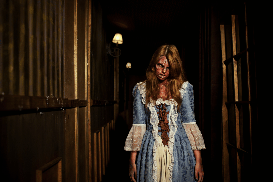 actress at a halloween haunted house at night dressed up scary