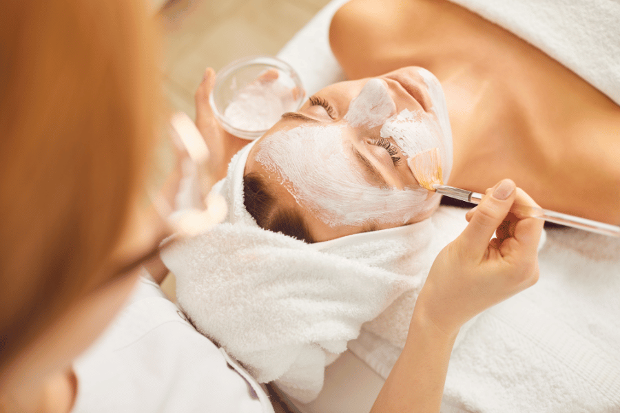 woman laying on a table getting a facial at a spa 