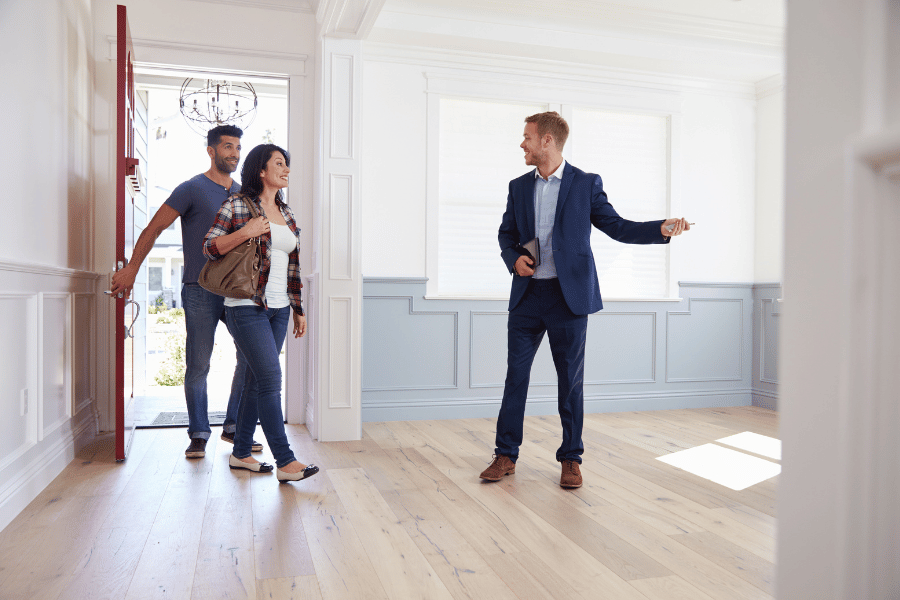 real estate agent showing potential buyers a home for sale