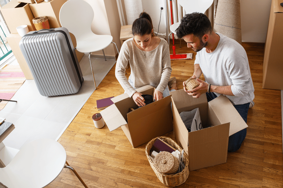 couple packing strategically for their move while sitting on the floor in their living room