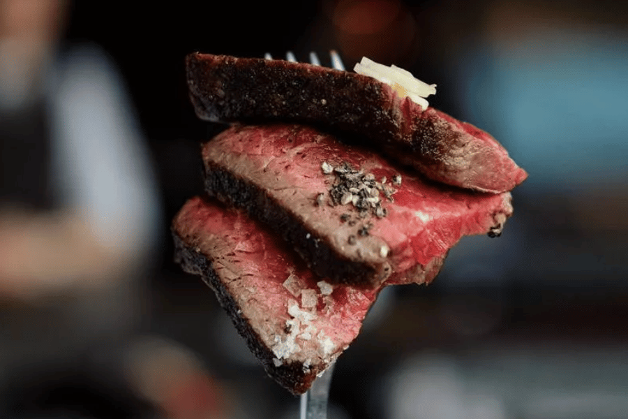 Steak on fork with seasoning 