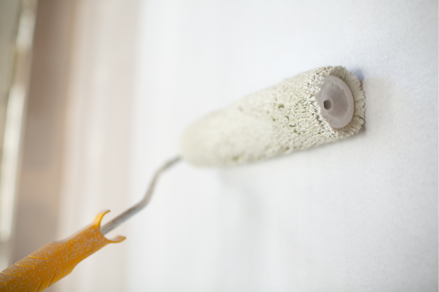 Paint Roller Rolling on beige paint onto walls