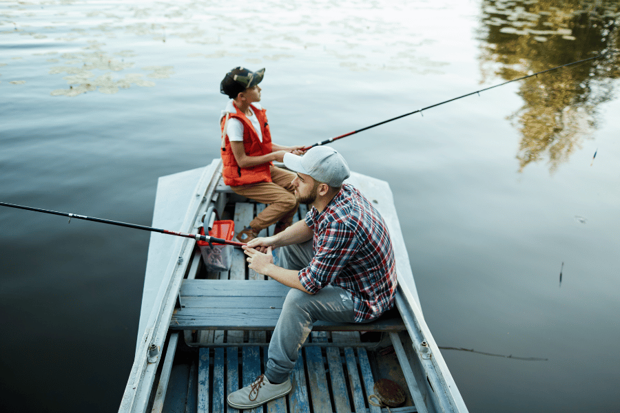 man and son fishing from a boat in a lake