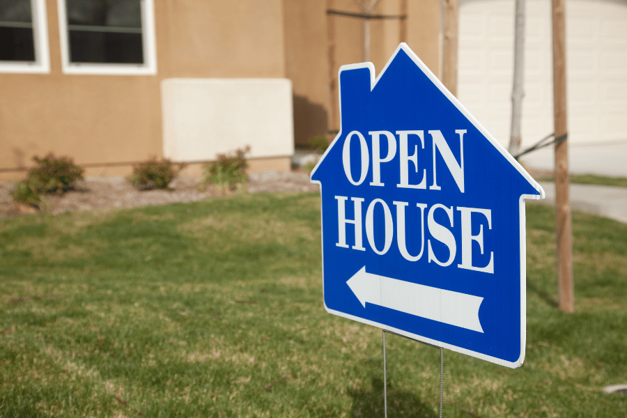 Blue open house sign in front of home for sale 