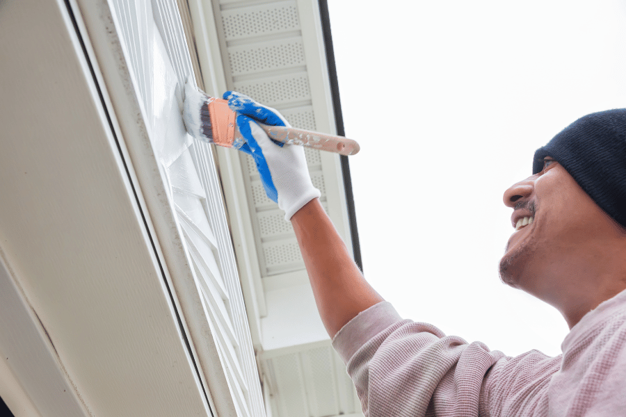 homeowner painting the exterior of home in good weather