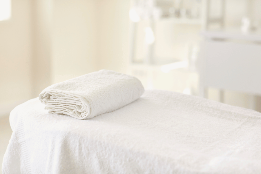 massage table at a spa covered in white towels 