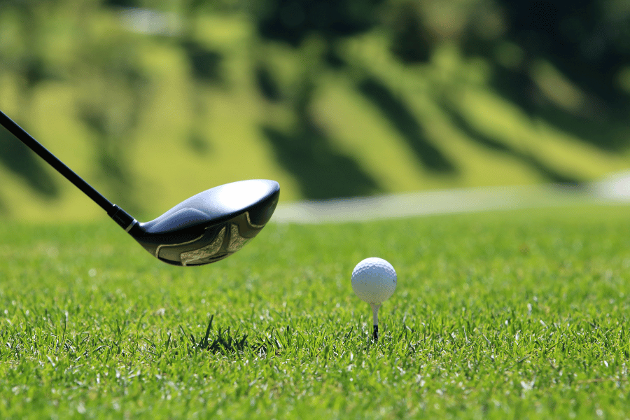 golf ball and club on a green golf course 