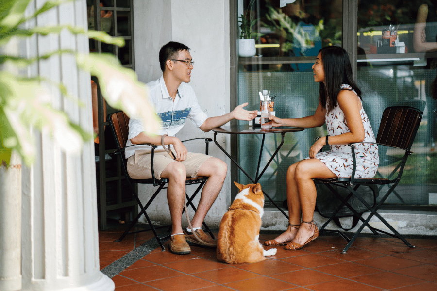 couple at a restaurant with their corgi outside 